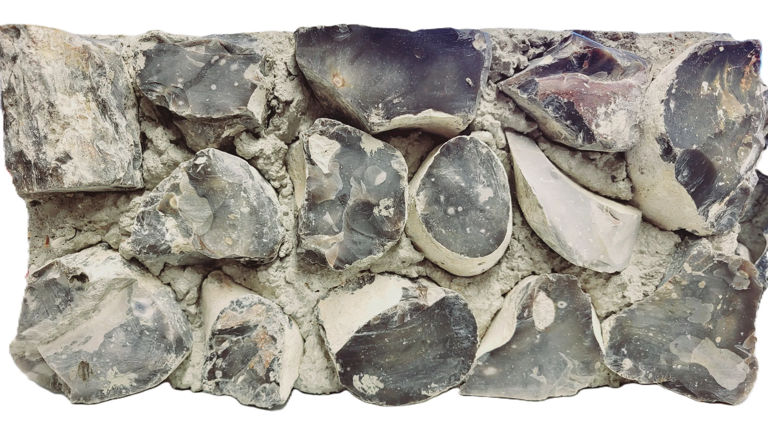A rectangular flint block of concrete embedded with irregularly shaped, dark flint stones is shown against a white background.