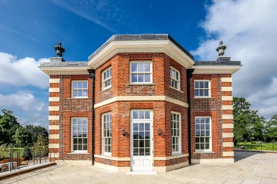 Hampton Court Pavilion replica with red brickwork, stone quoins, white sash windows and blue skies above