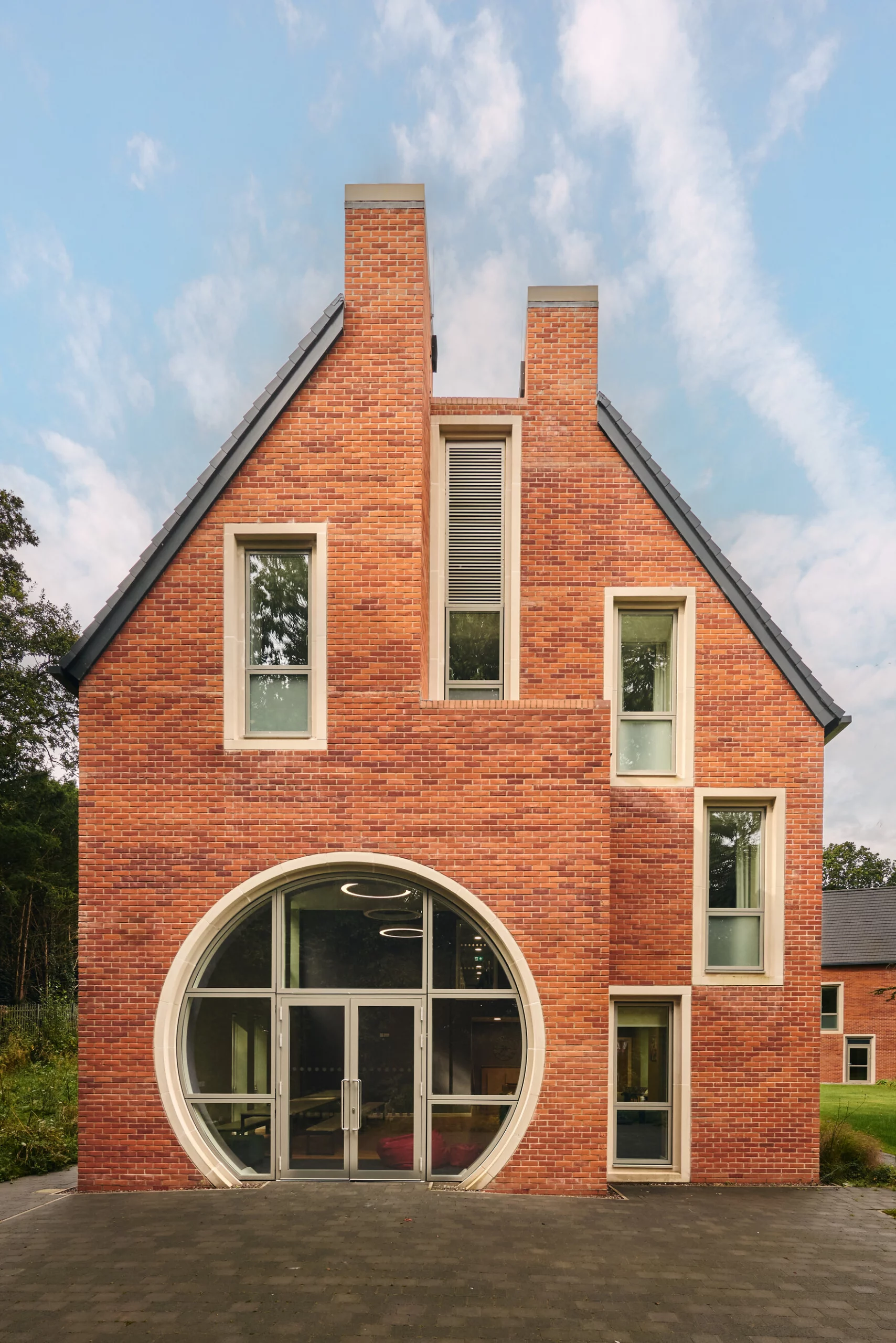 Stretcher Bond An end of a building with a large circular window with irregular placed windows with stone surrounds