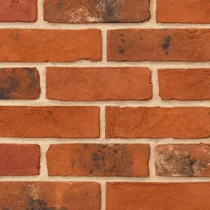 Red brick wall with beige mortar between evenly spaced rectangular bricks.
