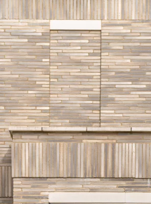 Grey Linear Brick A close-up view of a beige and light brown linear brick wall with horizontal and vertical patterns and a decorative rectangular panel in the centre.