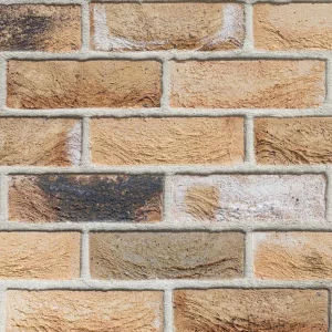 A wall with yellow and brown bricks laid in a stretcher pattern