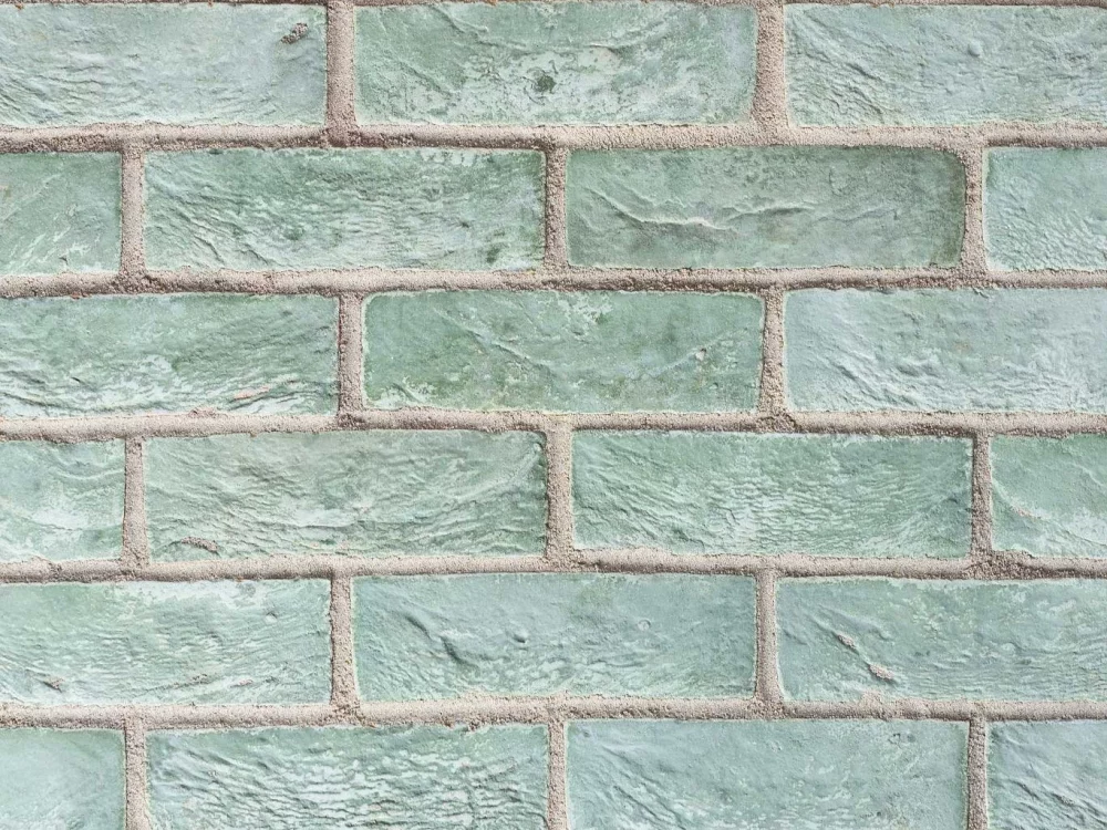 a close up of olive Green rectangular tiles with visible grout lines laid in a stretcher pattern