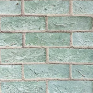 a close up of olive Green rectangular tiles with visible grout lines laid in a stretcher pattern