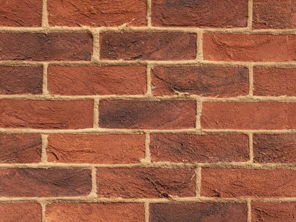 A close up of a Red Multi brick wall, featuring horizontal rows of red bricks and light-coloured mortar.
