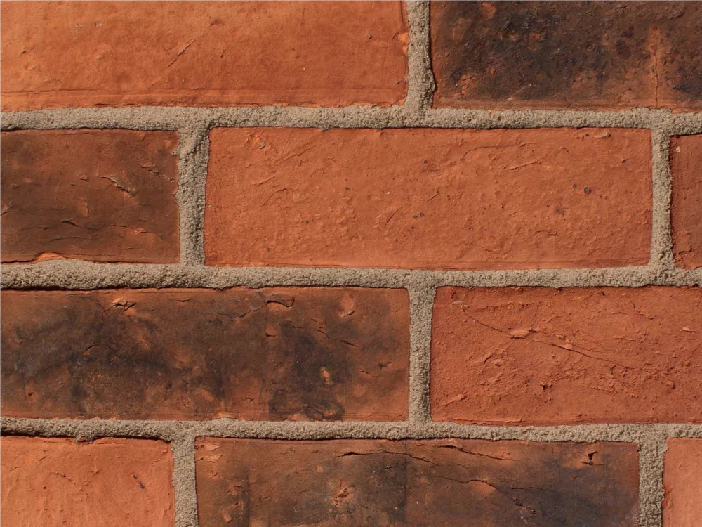 A brick panel wall with orange tones laid in a stretcher pattern with light coloured mortar