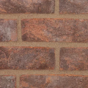 A brick wall showcasing grey and brown bricks laid in a stretcher pattern