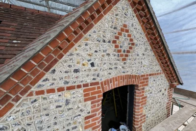 A gable end laid with flint blocks in a snail creep pattern and decorative brickwork surrounding the flint