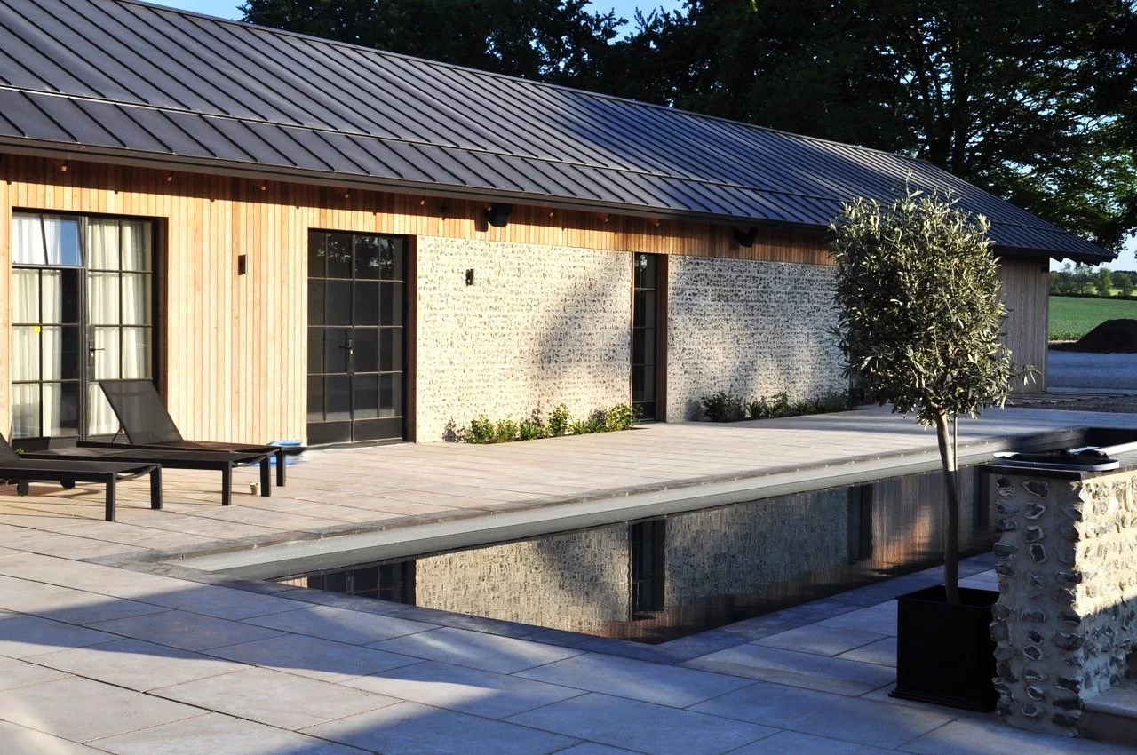 A loose flint wall for a barn with a grey slate roof