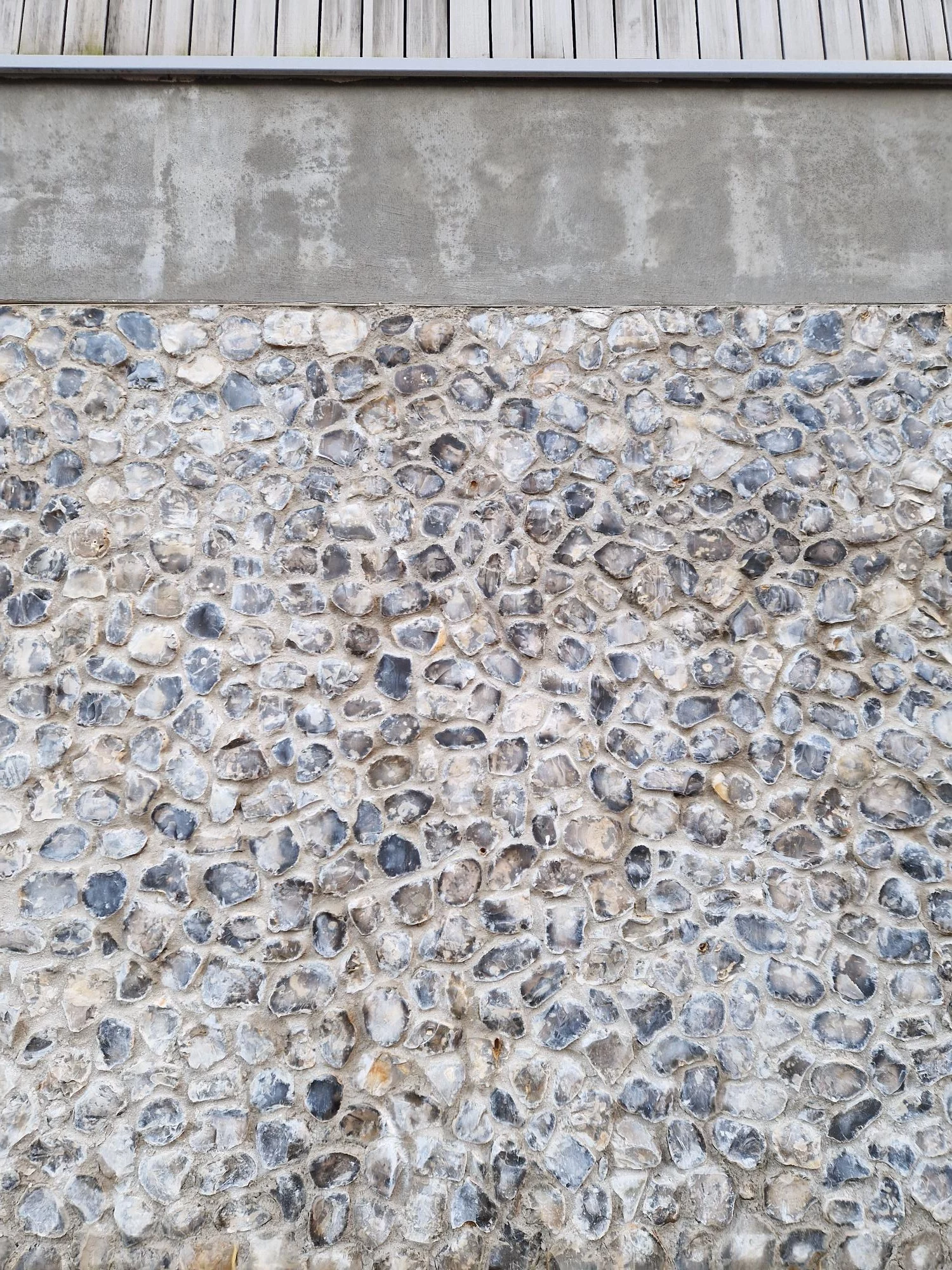 Loose flint sand and gravel wall showing the flint faces in greys and browns