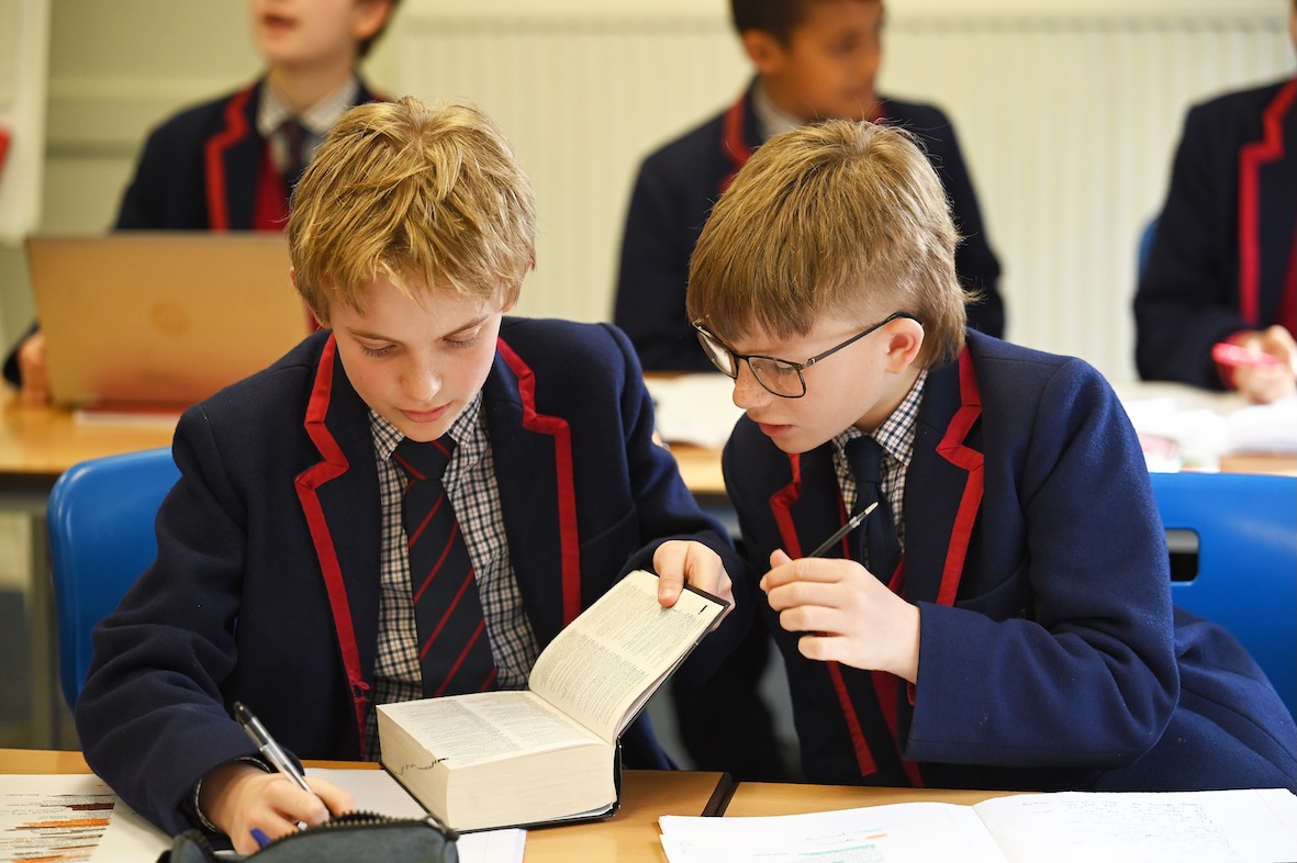 Two boys exploring a dictionary together during an English lesson at Swanbourne House.