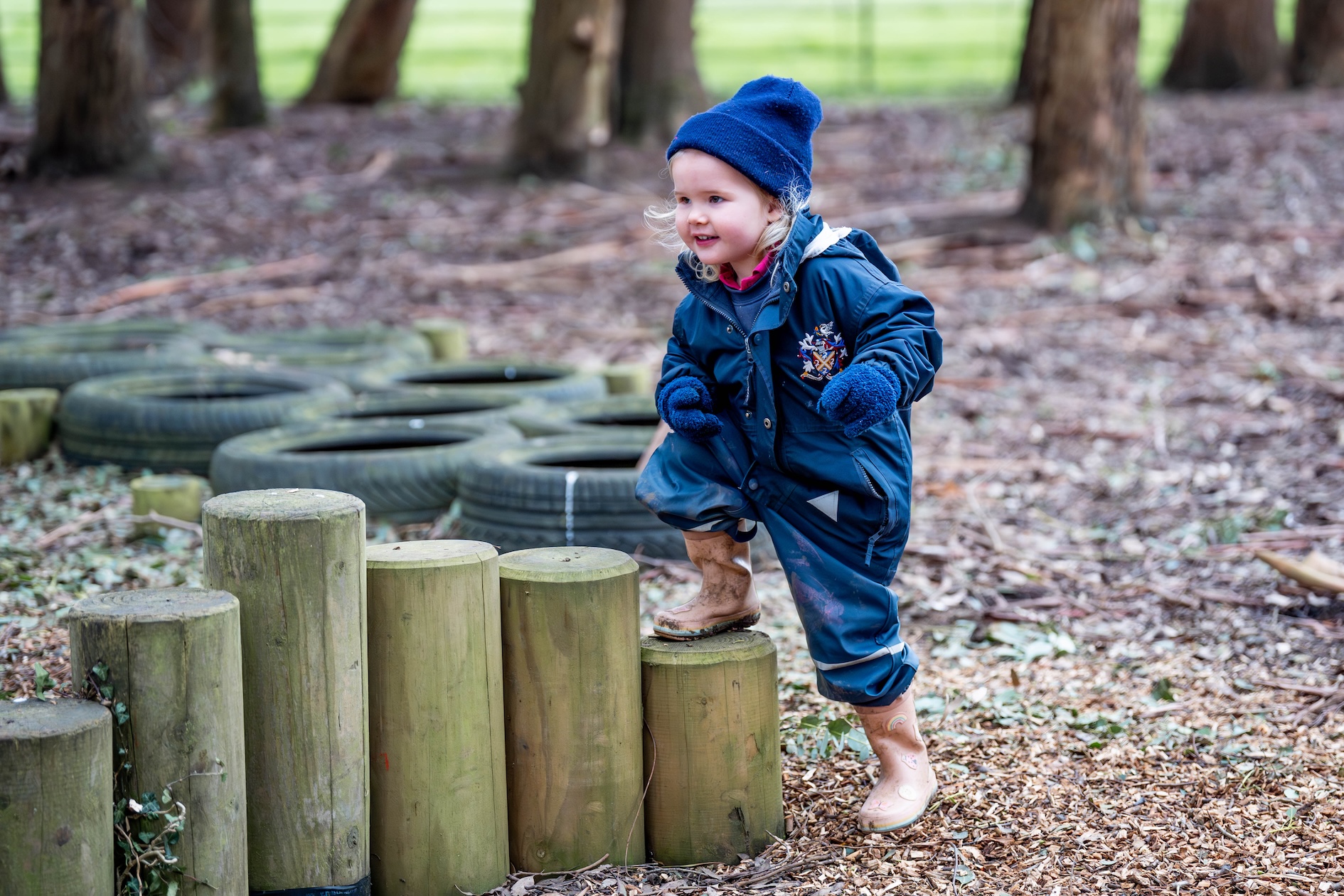 A Pre-Reception child playing in the woods at Manor House | Swanbourne House