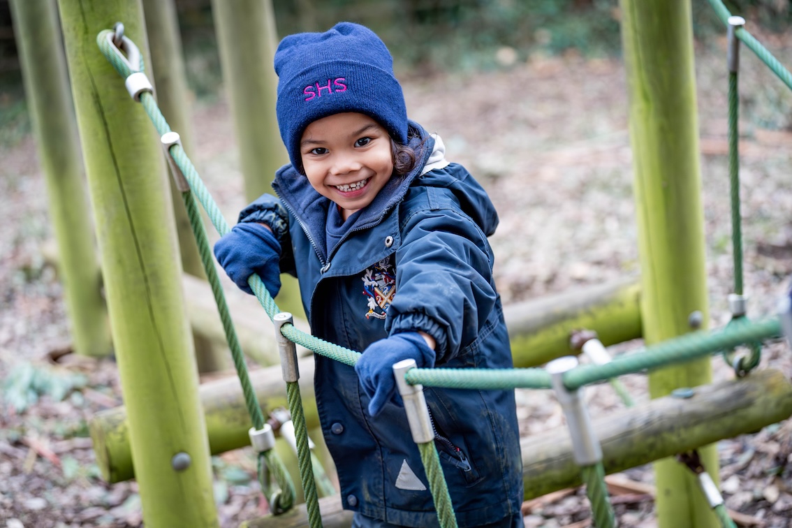 A happy child playing in the woods at Swanbourne House | Independent School Buckinghamshire