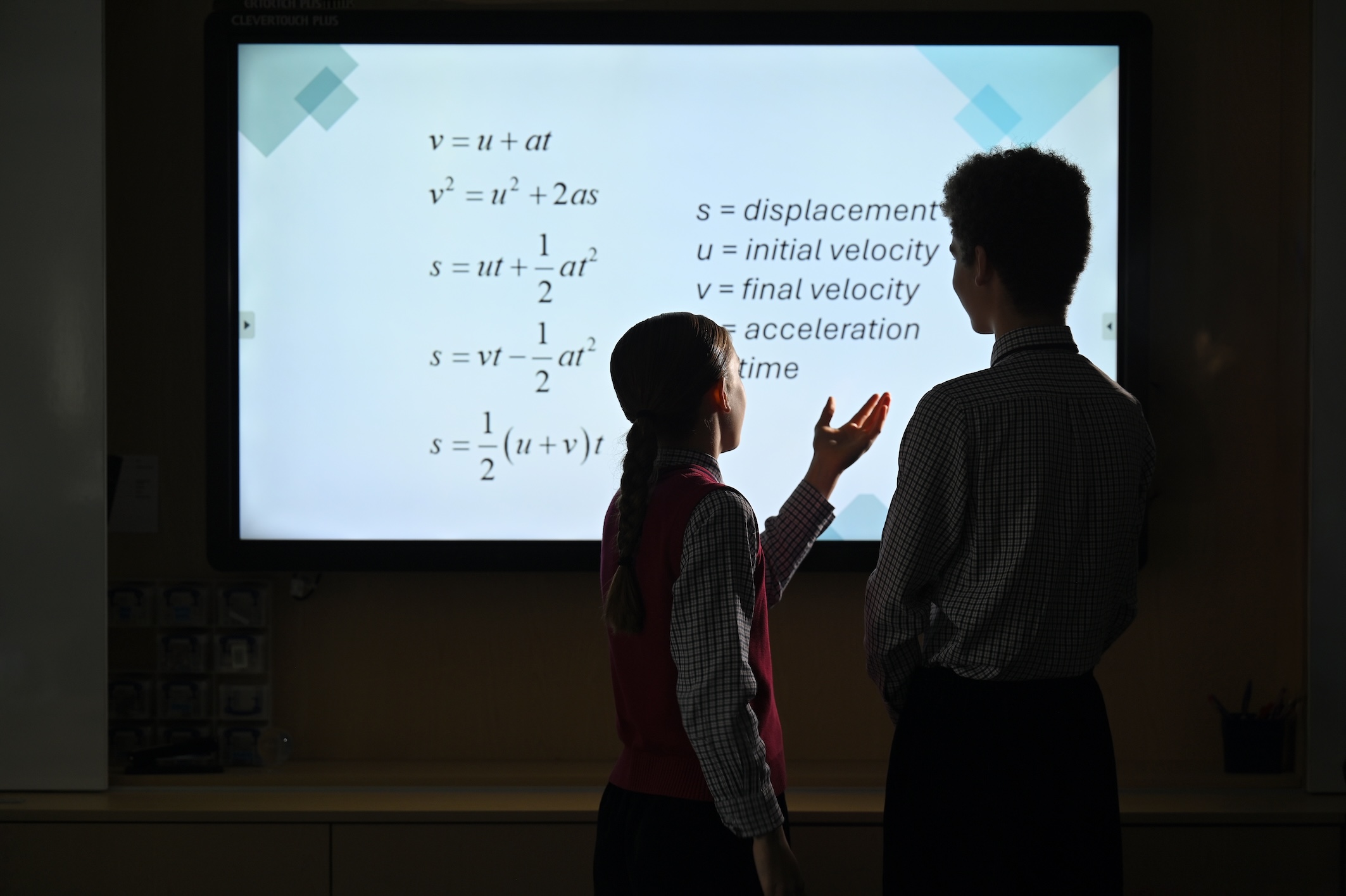 Prep school pupils solving maths equations on a classroom whiteboard at Swanbourne House Buckinghamshire.
