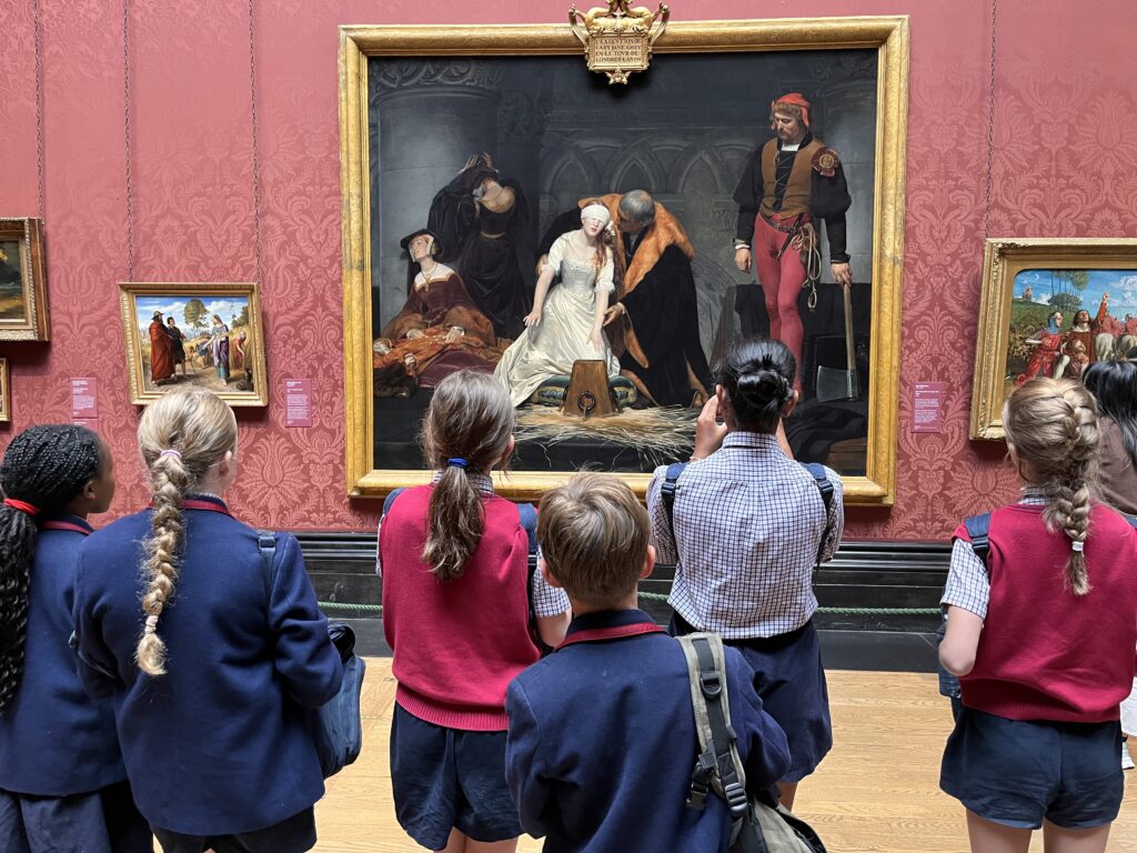 Swanbourne House Art Scholars observing and discussing a painting during an educational visit to London galleries.